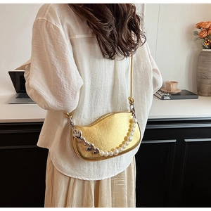 Détail du sac doré ondulé en PU avec chaîne de perles en cœur porté à l'épaule