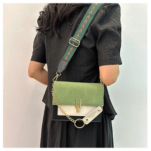 Detail of color-block crossbody bag with green suede flap and wide canvas shoulder strap