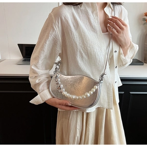 Détail du sac lune argenté avec perles et chaîne décorative à breloques en cœur