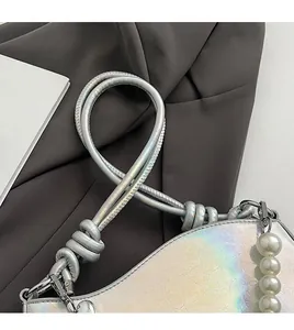 Détail du sac en cuir laser argenté avec chaîne de perles et bandoulière nouée
