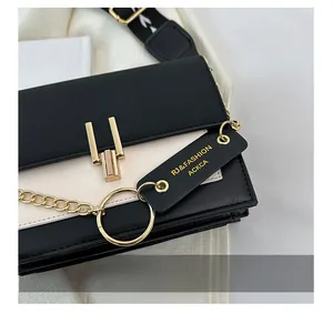 Detail of contrast crossbody bag with golden chain strap and magnetic lock closure