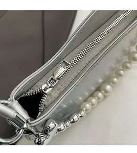 Vue détaillée de la fermeture éclair fluide et de la chaîne de perles du sac argenté