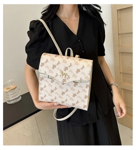 Détail de l'imprimé calèche classique et boucle cheval dorée sur un sac bandoulière beige