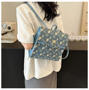 Sac à dos bleu avec motif carrosse doré et logo en métal porté par un mannequin