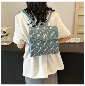 Détail du sac à dos en cuir bleu avec imprimé cheval et fermoir en métal doré
