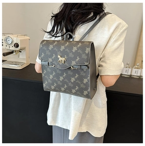 Gros plan détaillé du sac à dos taupe avec motif de carrosse et logo doré
