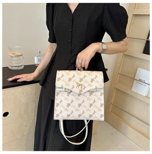 Gros plan sur sac à dos beige en cuir avec imprimé cheval et boucle dorée élégante
