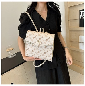 Détail du sac à dos beige vintage avec imprimé calèche et fermoir en métal doré