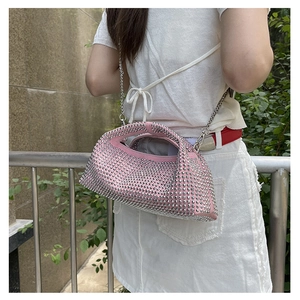 Detailed view of pink crossbody bag featuring silver stud accents and a metal chain strap