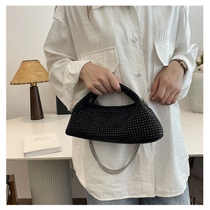 Detail of black beaded crescent handbag with silver chain held in a modern setting