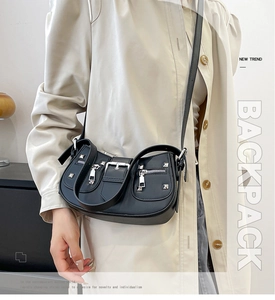 Detail of black motorcycle shoulder bag with silver rivets and metal hardware accents