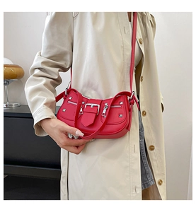 Close-up of bright red retro rivet shoulder bag with silver hardware and buckles
