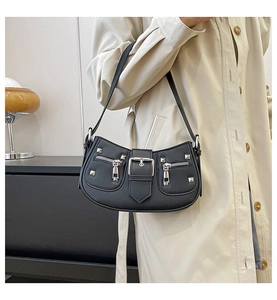 Detail of black punk shoulder bag with silver studs and zipper on faux leather