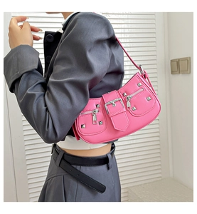 Detail of pink rivet baguette bag showing silver studs and decorative buckle on shoulder