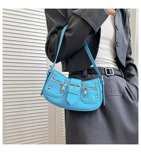 Close-up of sky blue rivet shoulder bag with silver metal hardware and punk studs