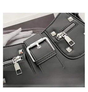 Detail of black motorcycle bag featuring silver square rivets and buckle straps