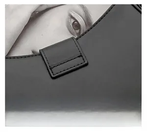 Close-up of precise stitching details on black vintage leather motorcycle shoulder bag