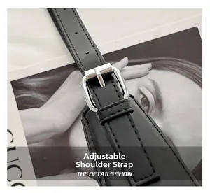 Detail of adjustable black leather strap with silver metal buckle on a retro rivet bag