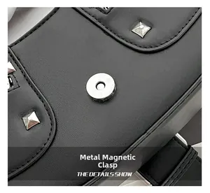 Macro view of silver magnetic buckle and pyramid studs on black leather handbag