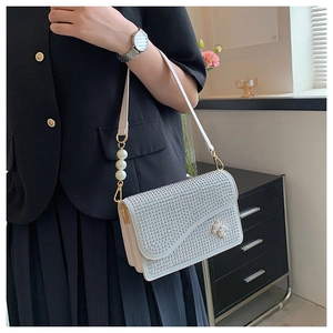 Detail of white rhinestone crossbody bag with pearl floral accents and strap