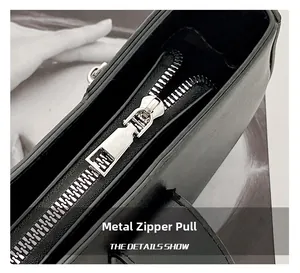 Macro shot of polished silver metal zipper pull on textured black leather bag