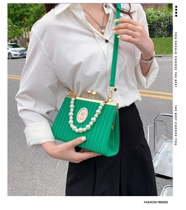 Close-up of bright green embossed handbag with pearl handle and vintage relief detail
