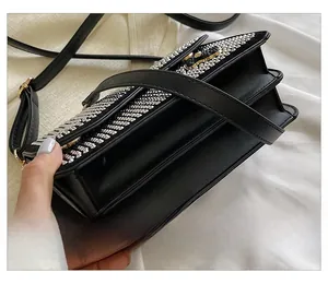 Detail of black crossbody bag with multi-row silver rhinestones and gold hardware
