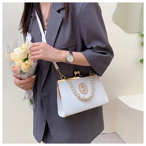 Détail du sac bandoulière blanc plissé avec camée vintage et poignée en perles
