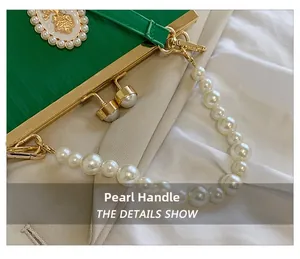 Close-up of elegant green evening bag featuring a pearl handle and gold clasp detail