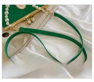 Detail of green evening bag with pearl handle and golden metal frame clasp closure