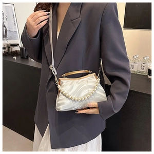 Detailed view of the pearl white pleated shell bag with oversized faux pearl handle and strap
