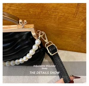 Detail of adjustable leather strap and golden metal buckle on a shell handbag
