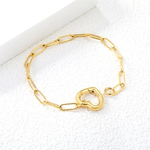 Macro shot of gold paperclip chain bracelet featuring a large heart-shaped clasp toggle