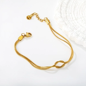 Detail of 18K gold stainless steel snake chain bracelet with elegant knot design