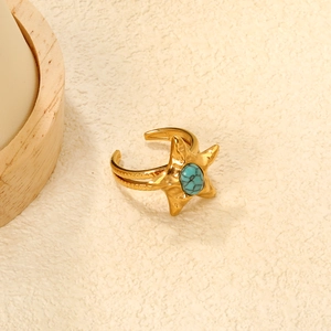 Bohemian gold star ring with turquoise stone on a minimalist textured background