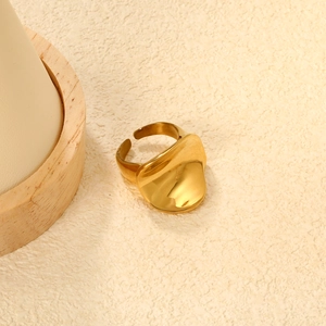 Dettaglio anello irregolare in acciaio inossidabile placcato oro 18K su base beige
