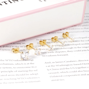 Detail view of four pairs of graduated round zircon stud earrings in gold 4-prong setting