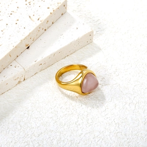 Vintage gold stainless steel ring featuring a soft pink stone inlay on a stone backdrop