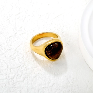 Vintage gold stainless steel ring featuring an oval tiger eye stone on a clean background