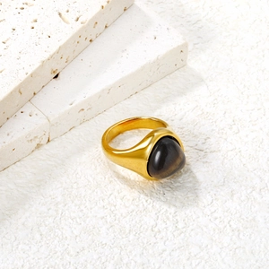 Macro detail of vintage gold ring featuring a polished oval tiger eye gemstone inlay