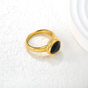 Detailed view of emerald cut oval stone on a wide gold plated stainless steel ring
