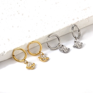 Vue macro des boucles d'oreilles planétaires en or et argent avec diamants micro-incrustés