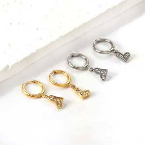 Détail des boucles d'oreilles créoles cœur dorées et argentées avec strass brillants
