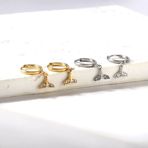 Détails de boucles d'oreilles queue de baleine or et argent avec zircons sur socle en pierre