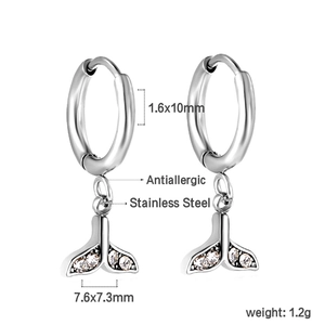 Détail macro des boucles d'oreilles en acier inoxydable avec pendentif queue de poisson