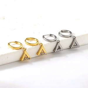 Vue détaillée de boucles d'oreilles triangles argentées et dorées avec petits cristaux