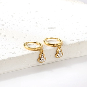 Gros plan de boucles d'oreilles gourde plaquées or serties de zircons blancs