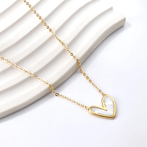 Gros plan du collier coeur doré avec incrustation de nacre sur support blanc