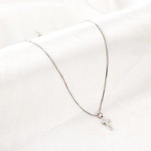 Détail du pendentif croix en acier inoxydable argenté avec cristaux sur chaîne