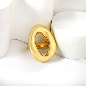 Artistic display of a hollow oval gold ring on white geometric pedestals